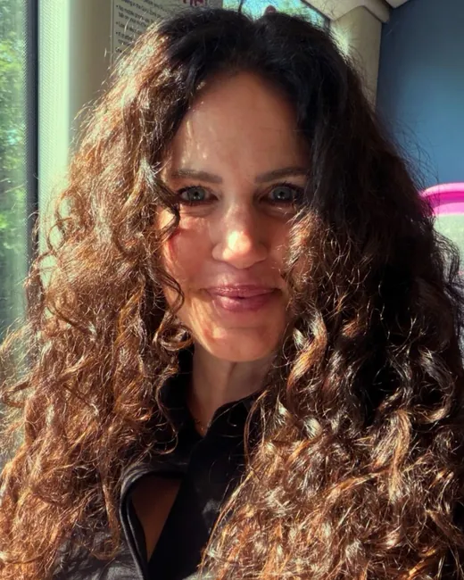 Tanya Hill smiling, with long curly hair
